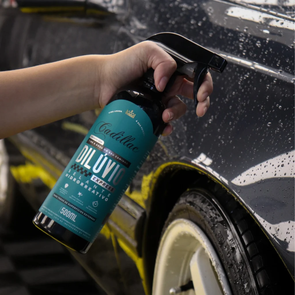 mão segurando um spray do produto diluvio com um carro ao fundo